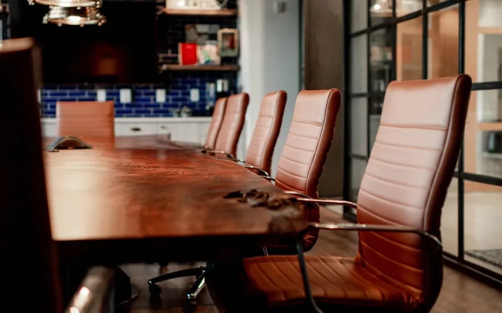 Conference room with a large wooden table and leather chairs